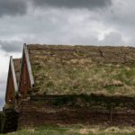 Natural Insulation - a building with a grass roof and a flag on top of it