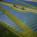 Renewable Energy - aerial photography of grass field with blue solar panels