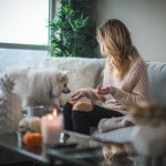 Winterize Home - woman sitting on sofa while holding food for dog