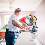 DIY Plumbing - man standing infront of miter saw