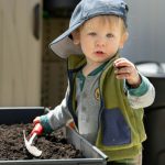 Raised Garden Bed - a baby holding a toothbrush