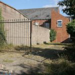 Backyard Privacy - an old brick building with a gate in front of it