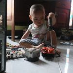 Durable Flooring - a little boy sitting on the floor playing with a toy