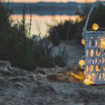 Outdoor Decor - yellow candle lantern on brown sand