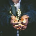 Energy Management - man holding incandescent bulb