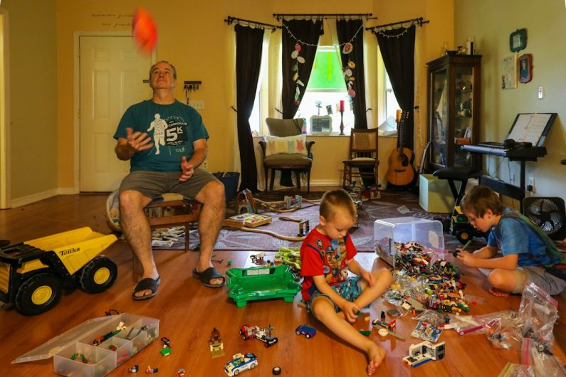 Home Toys - man in gray crew neck t-shirt sitting beside boy in red and white crew neck